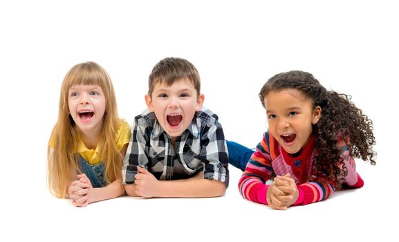 three funny children lying on the floor with open mouths isolated on white background