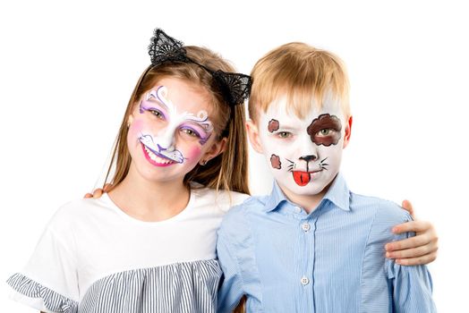 Happy children with face paintings hugging each other and smiling isolated on white background