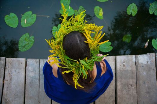 girl by the lake with a wreath on head.