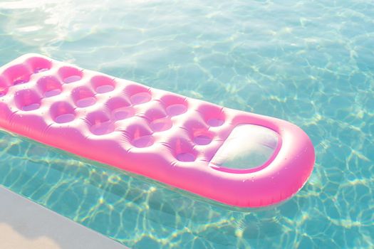 pink mattress in the swimming pool sunny day.