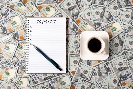 To do list banner with copy space. Notepad, pen and a cup of black coffee isolated on money background. Notepad with copy space. Office, business, discreet style.