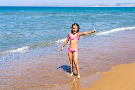 Adorable little girl at beach during summer vacation.