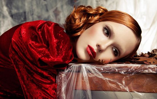 portrait of beautiful woman laying on table against autumn decoration