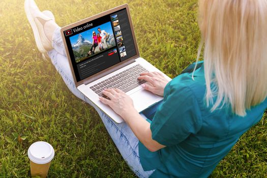 Woman watching videos online on laptop.