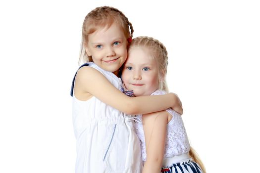 Two cute little girls close-up, in the studio on a white background. The concept of a happy childhood, Beauty and fashion. Isolated.