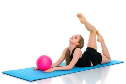 A charming little girl is engaged in fitness with a ball. The concept of gymnastics, health and sports. Isolated on white background.