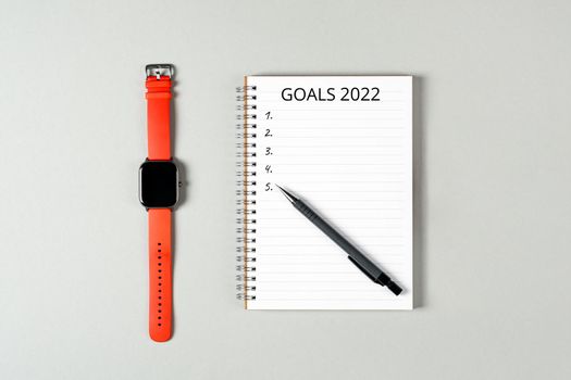 2022 goals concept banner. Notebook, pencil and a cup of black coffee isolated on gray background.