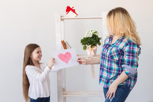 Mother's Day and family holidays - Mother reading greeting card from daughter.