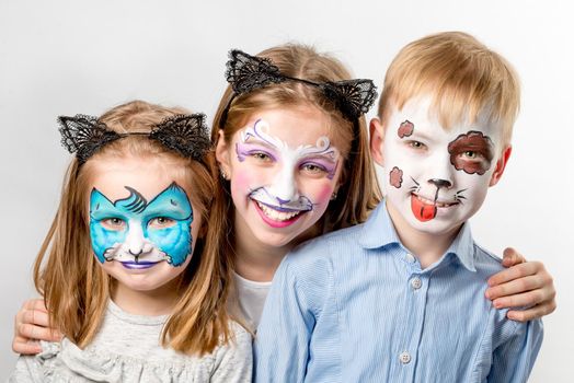 Funny children with animal face art paintings smiling isolated on white background