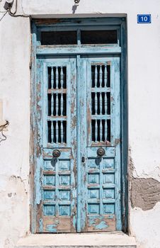 Old painted blue wooden door with cracked paint. Vintage blue door on the streets of Greece