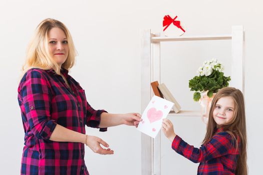 Mother's Day and family holidays - Mother reading greeting card from daughter.