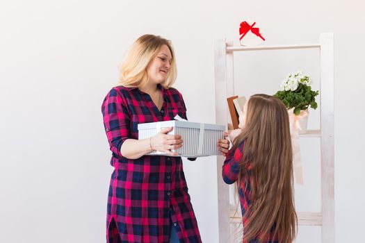 Young mother received a surprise from her daughter feeling excited open the mouth and looking at the gift in amazement in mother's day. Holidays, birthday and presents concept