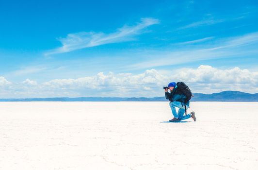 Tourist with equipment taking photo in sunshine Salar de Uyuni