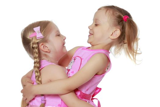 Two cute little girls close-up, in the studio on a white background. The concept of a happy childhood, Beauty and fashion. Isolated.