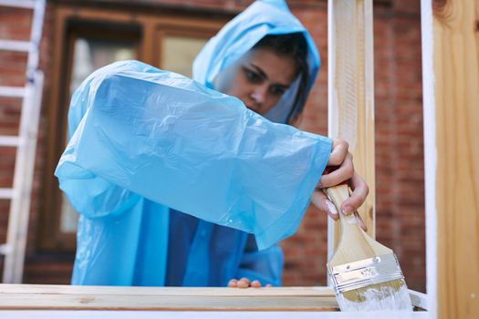 woman paints wood painter repair protective suit. High quality photo