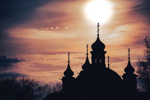 Silhouette of church in Belarus at sunset with clouds and sky in background