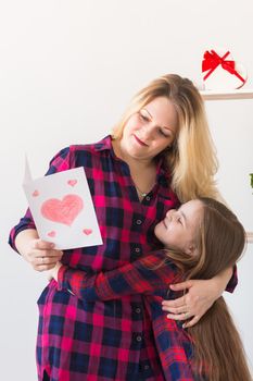 Mother's Day and family holidays - Mother reading greeting card from daughter.