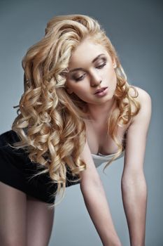 Well-being & spa. Sensual woman model with shiny curly long blond hair. Health, beauty, wellness, haircare, cosmetics and make-up
