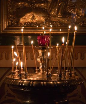 photo of burning candles in church with dark background