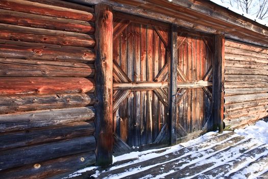 wooden farm barn house with closed door in winter