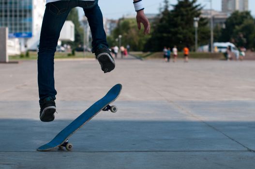 young skater perfoming stunt on his blue board