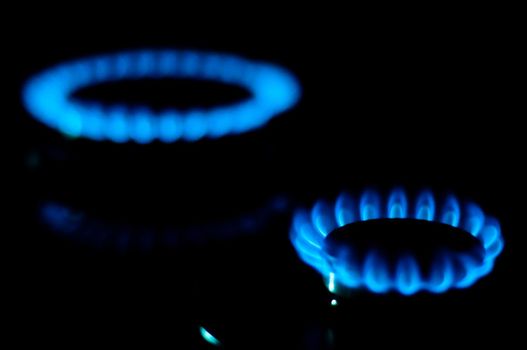 kitchen gas burning with blue flame isolated on black background