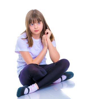 Little girl is sitting on the floor. The concept of a happy childhood. Isolated on white background.