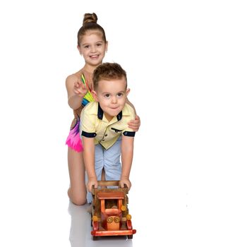 Brother and sister are playing with a toy car. The concept of happy childhood, people, harmonious development of the child in the family. Isolated on white background.