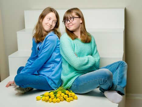 Two cute little girls close-up, in the studio on a white background. The concept of a happy childhood, Beauty and fashion. Isolated.