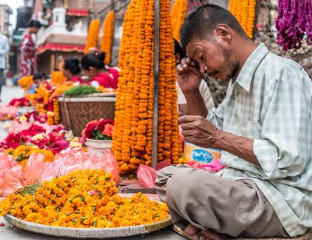 KATHMANDU, - OCTOBER 05: People sell flower necklaces near to Kathmandu Durbar Square in Kathmandu, Nepal, October 05, 2017