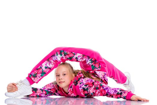 A girl gymnast performs an acrobatic element on the floor. The concept of childhood, sport, healthy lifestyle. Isolated on white background.