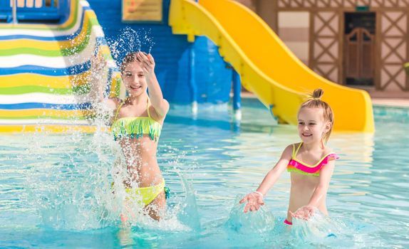 Cute smiling girl is enjoying clean water in the swimming pool