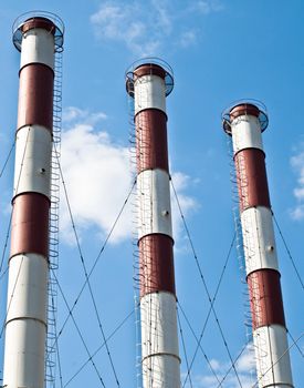 three factory pipe with blue cloudy sky in background