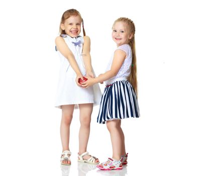 Two cute little girls with apples, in the studio on a white background. Concept of happy childhood, healthy eating. Isolated.