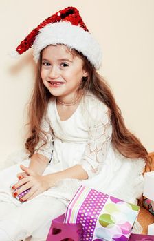 little cute girl in santas red hat waiting for Christmas gifts. holiday lifestyle people concept close up