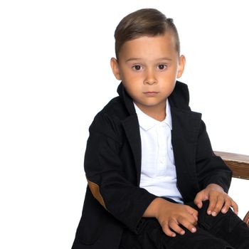 A sad little boy in the studio on a white background. The concept of child development in the family, emotions. Isolated.