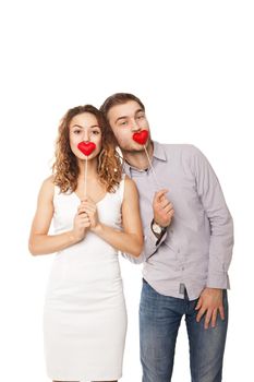 Portrait of joyful couple holding red hearts and laughing isolated on white