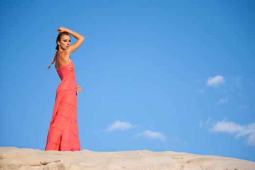 Portrait of a beauty woman in red dress on the desert