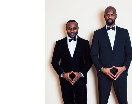 two afro-american businessmen in black suits emotional posing, gesturing, smiling. wearing bow-ties close up