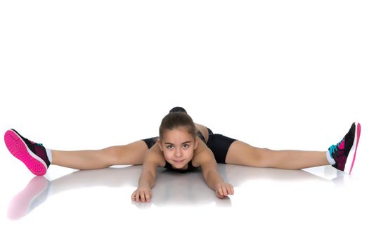 A little girl performs a gymnastic twine. The concept of fitness and sports. Isolated on white background.