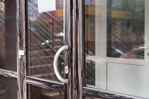 The front door of a office block, reflecting buildings in the glass.