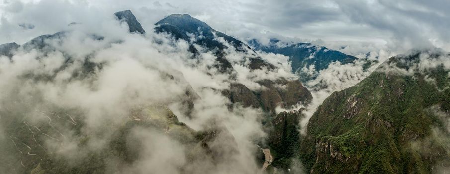 Majestic Machupicchu forested and covered with clouds, aerial view