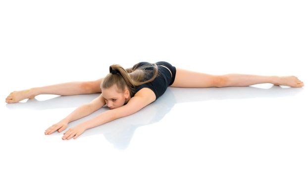 A little girl performs a gymnastic twine. The concept of fitness and sports. Isolated on white background.