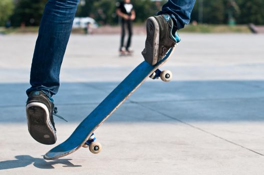 young skater perfoming stunt on his blue board