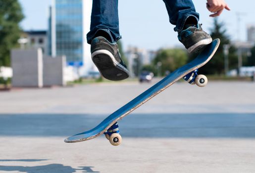 young skater perfoming stunt on his blue board