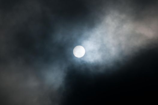 sun in the haze among dramatic dark clouds