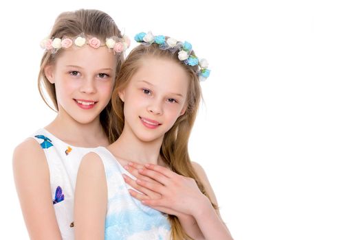 Two cute little girls close-up, in the studio on a white background. The concept of a happy childhood, Beauty and fashion. Isolated.