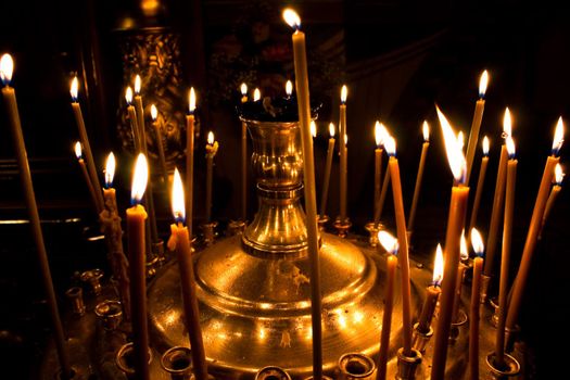 photo of burning candles in church with dark background