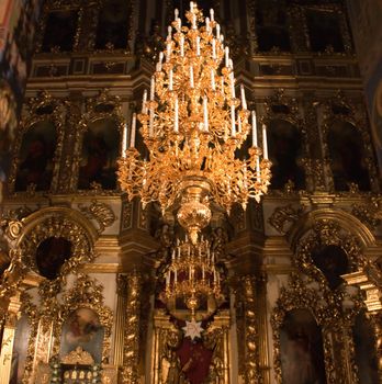 photo of iconostasis with chandelier in foreground in russian church