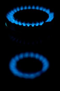 kitchen gas burning with blue flame isolated on black background